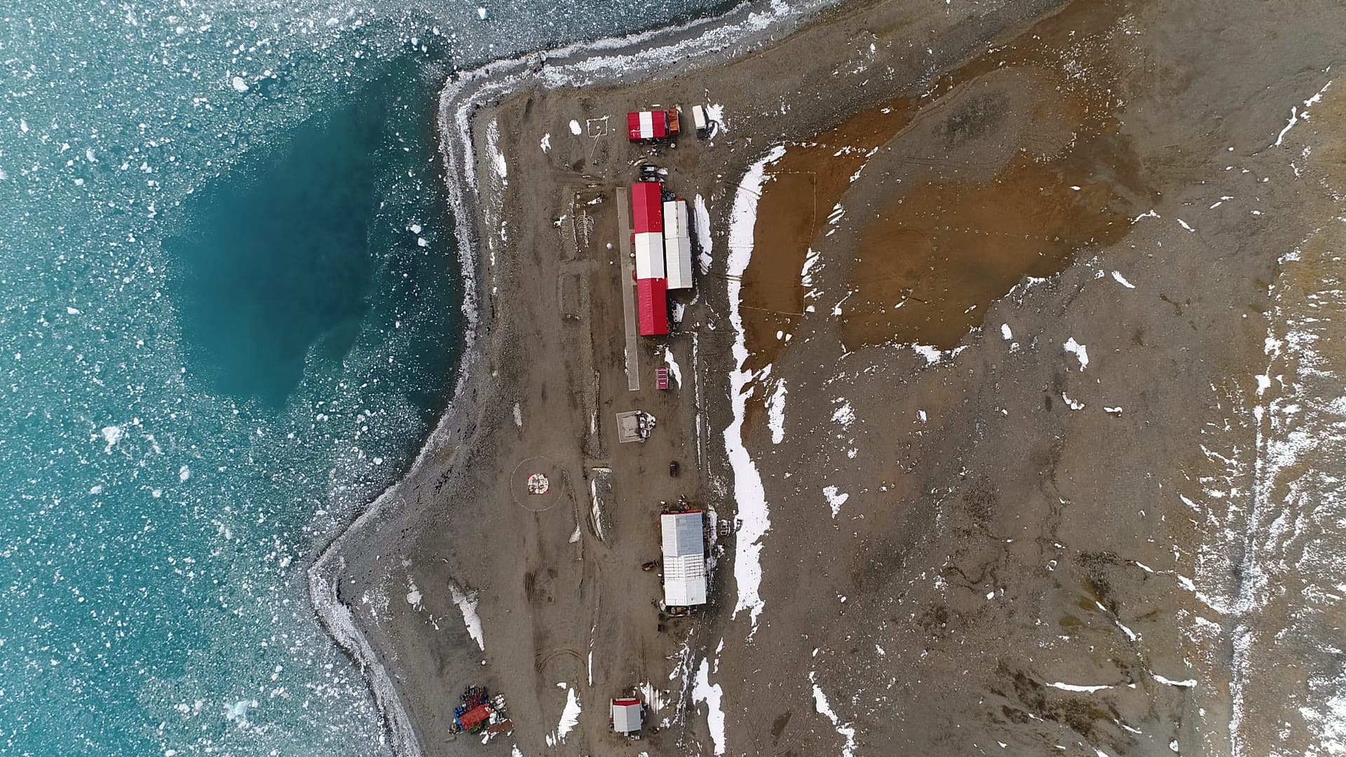 The base seen from directly above, ochre rock meeting turquoise water