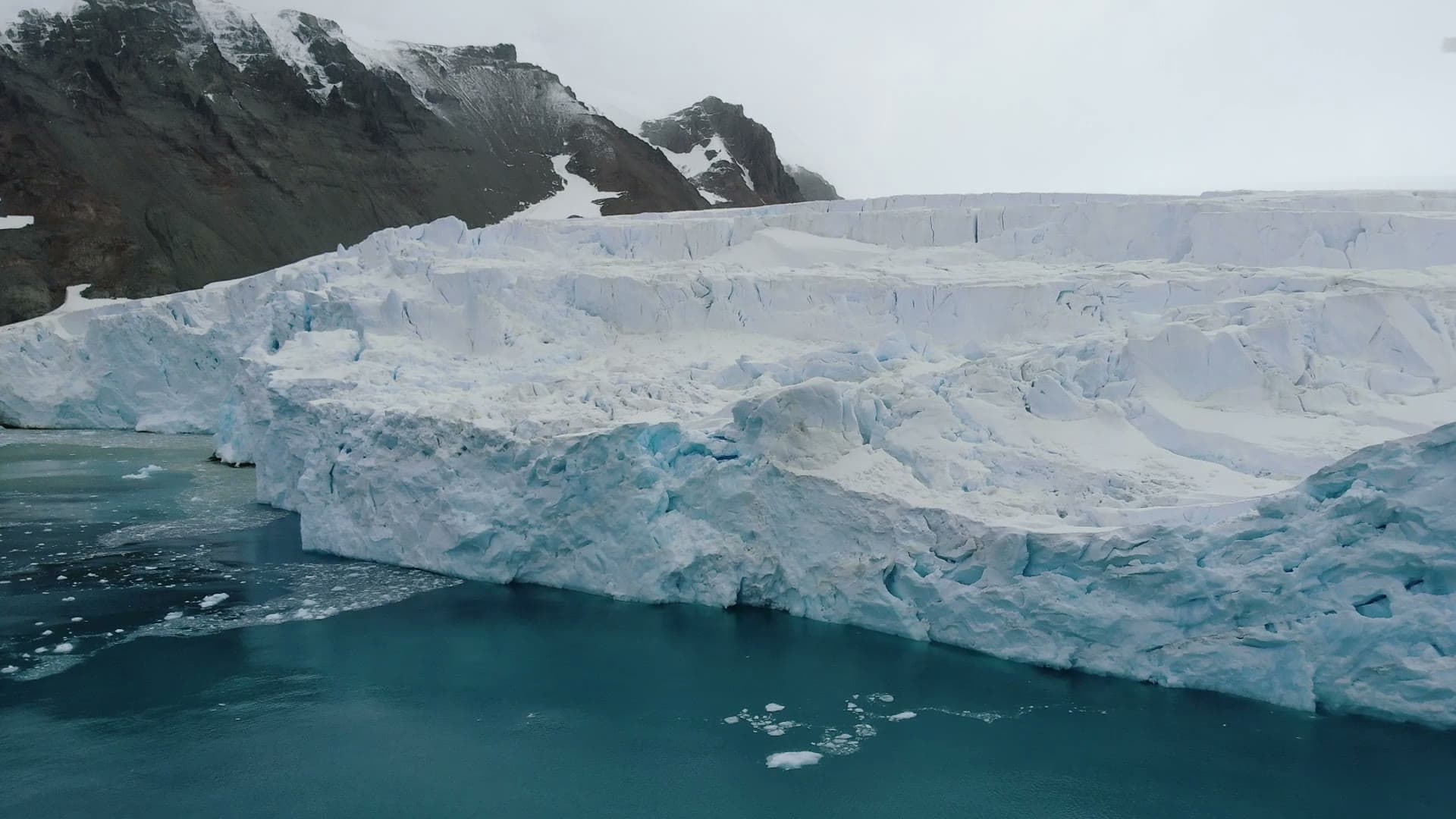 The layered calving face of the glacier seen from the water