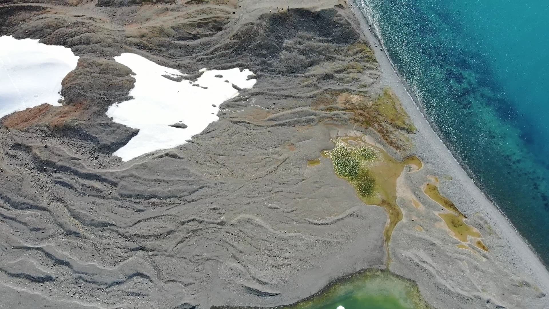 A turquoise meltwater lagoon seen from above