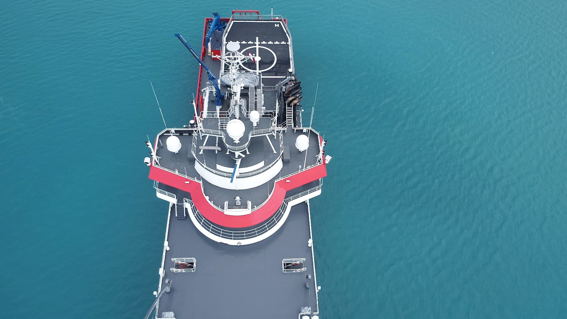 Research vessel seen from directly above on turquoise water
